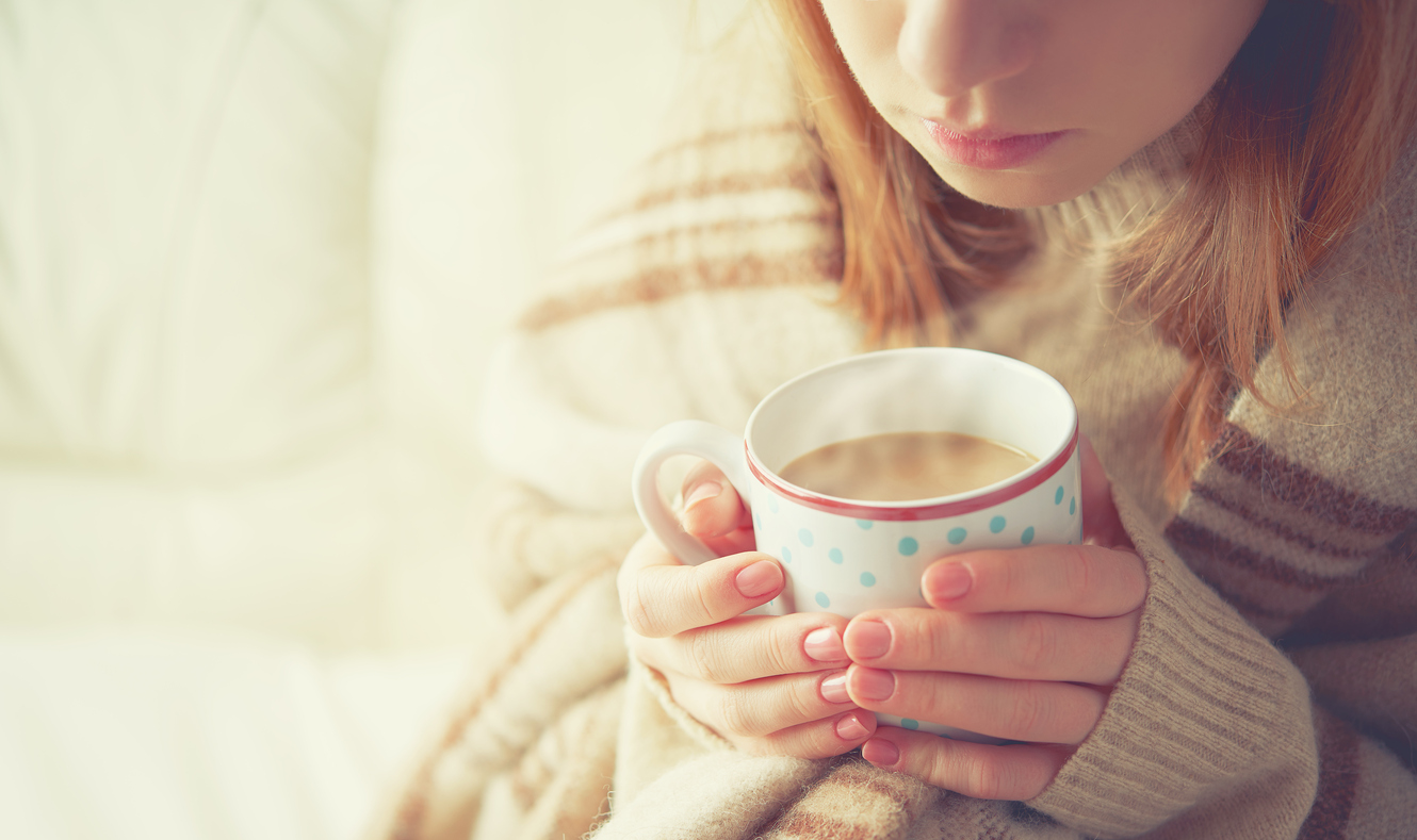 cup of hot coffee warming in the hands of girl