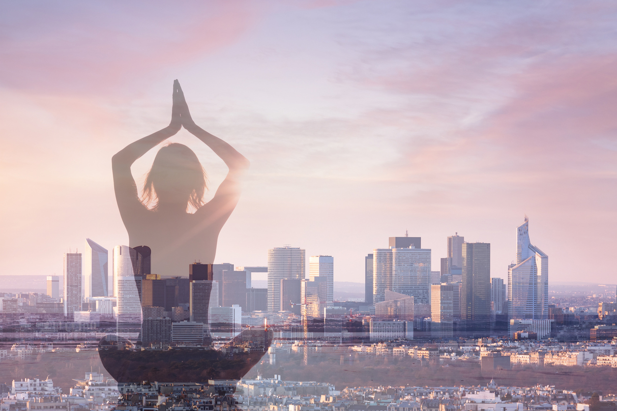 Double exposure of woman practicing yoga and city background with office building, concept about revitalizing in modern business life