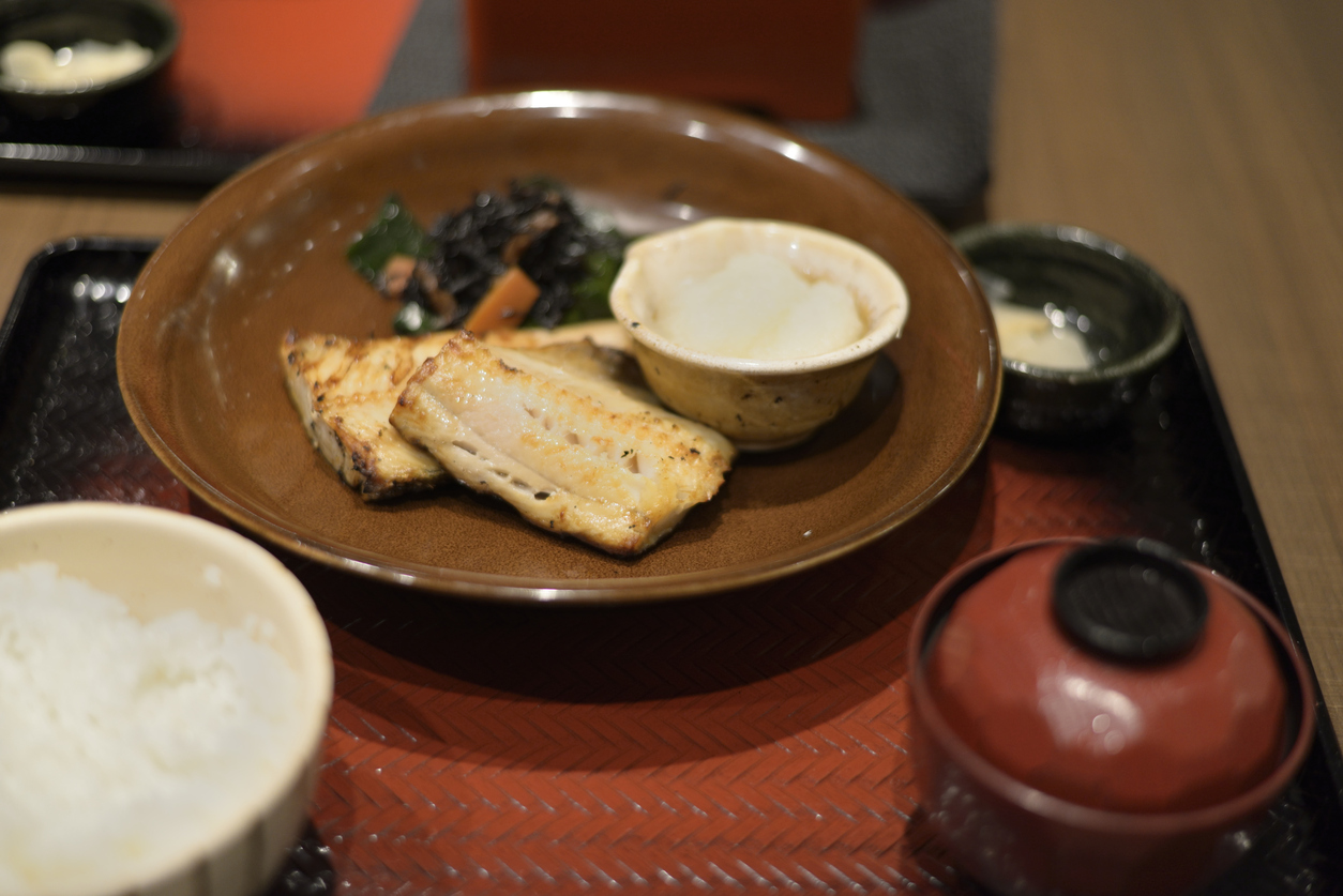 A japanese meal set with grilled fish, miso soup and rice.
