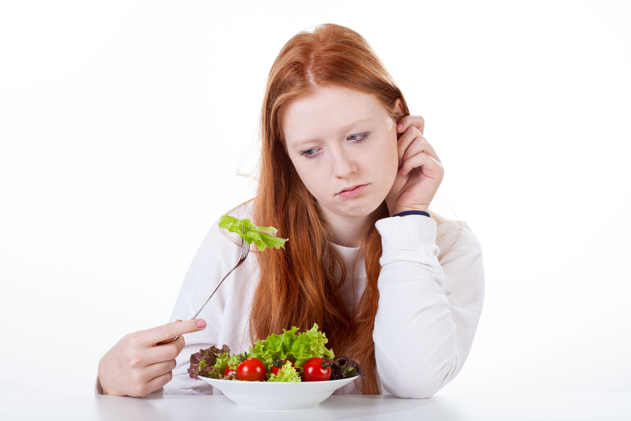 Teenage girl with no appetite on white isolated background