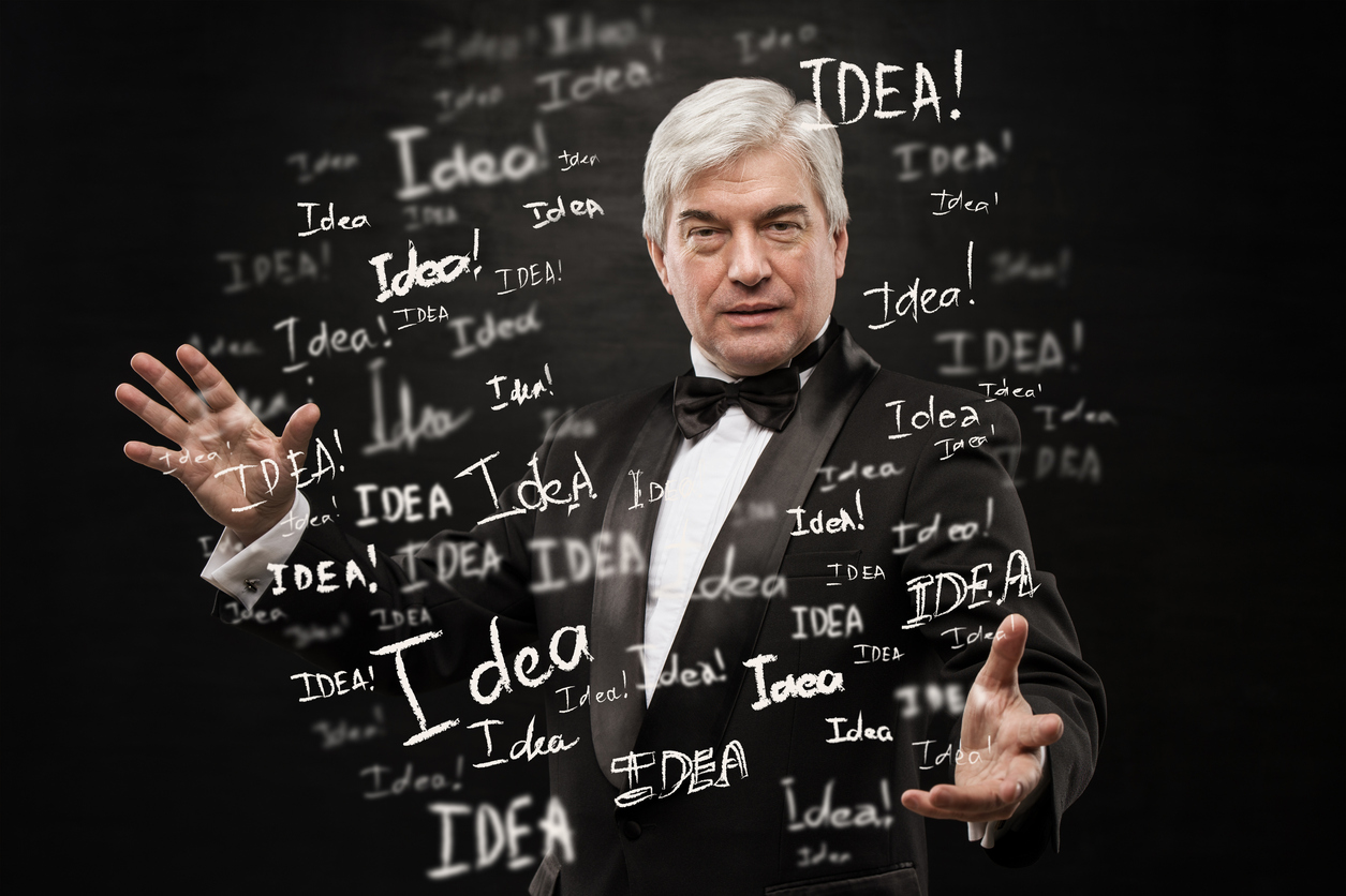 Mature businessman standing with idea signs on black background