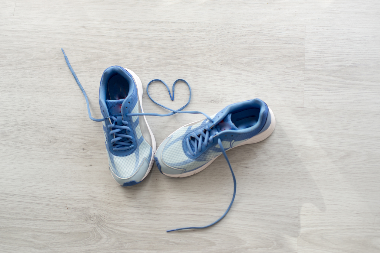 Love sign, Selective focus close up blue sport shoes on gray floor.