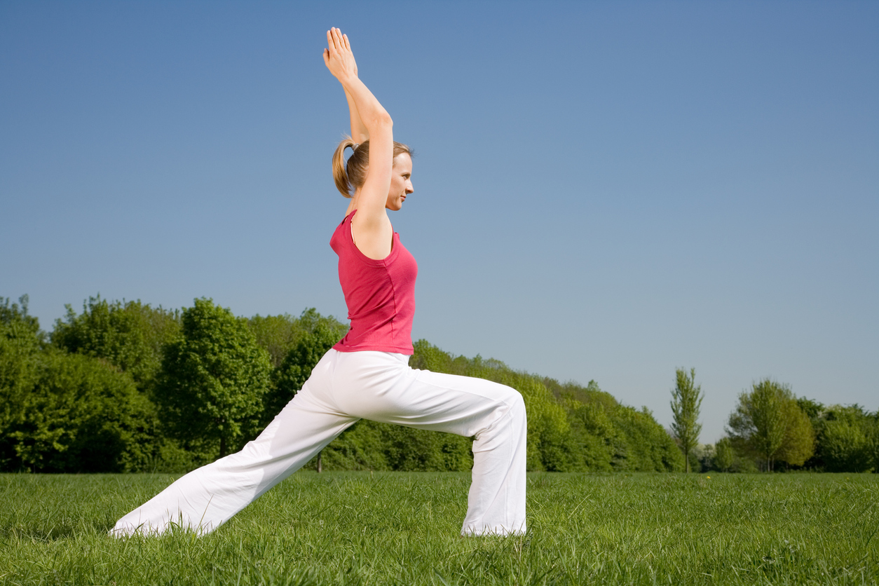 Young Blonde Woman Practicing Yoga Outdoors In The Park