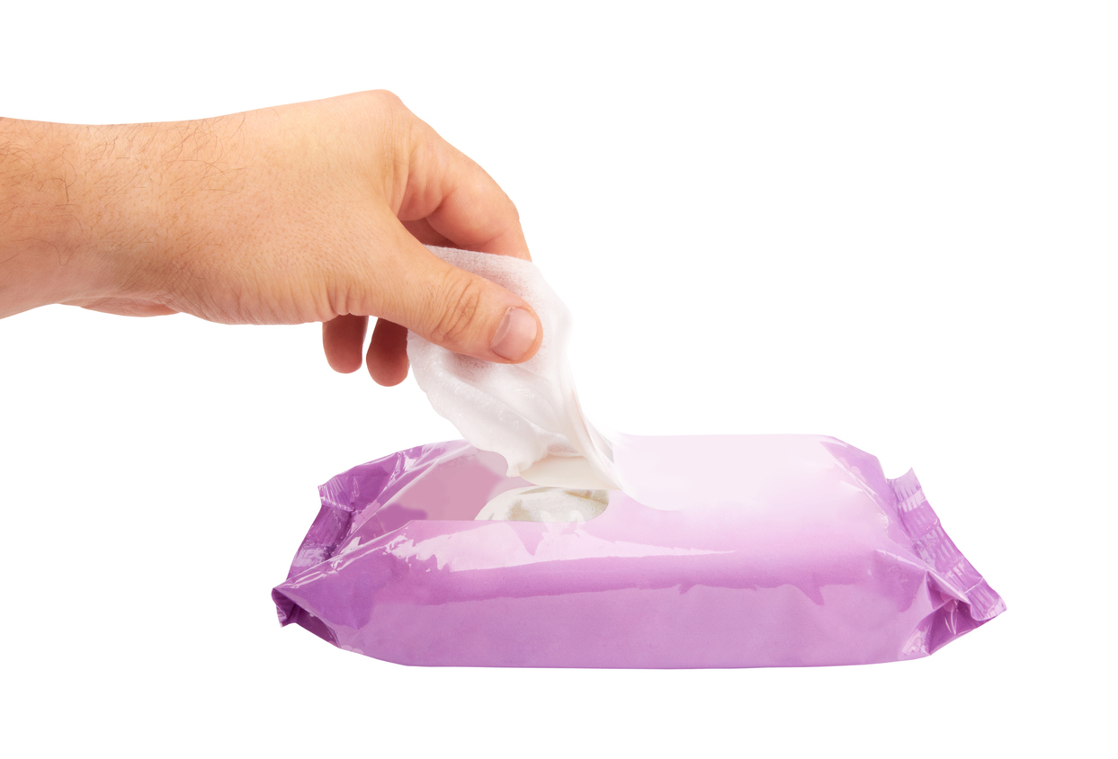 male hand pulling white facial tissue from a box