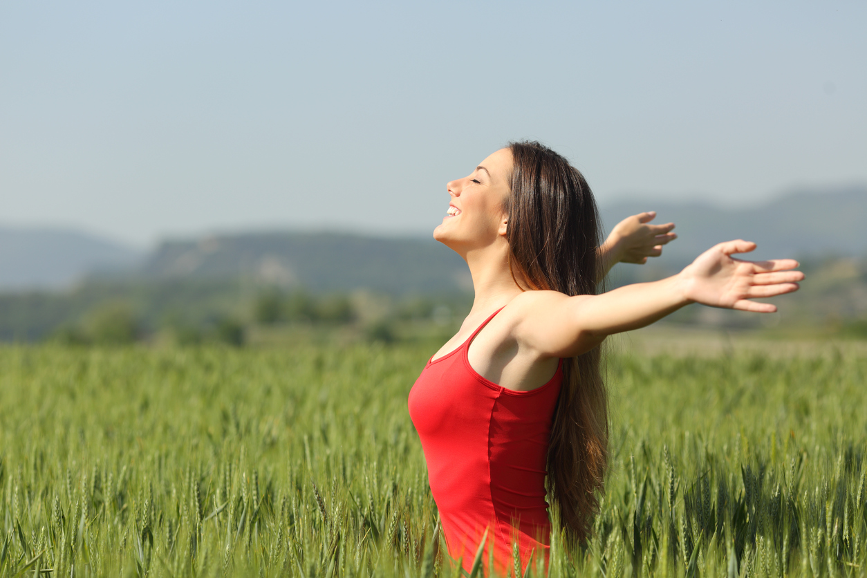 Woman breathing deep fresh air in a field