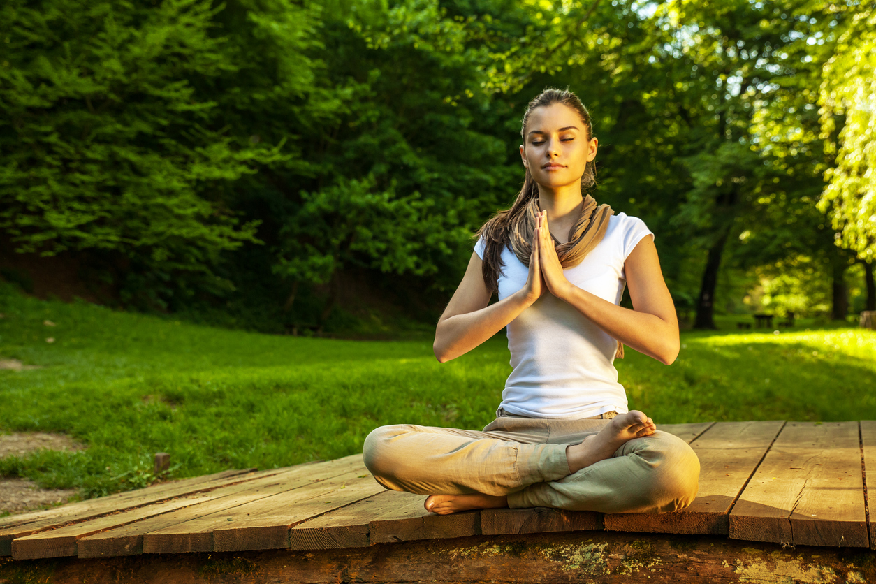 Attractive female meditate in nature.Lotus position.