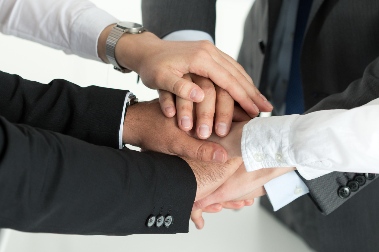 Closeup of business team showing unity with putting their hands together on top of each other. Concept of teamwork.