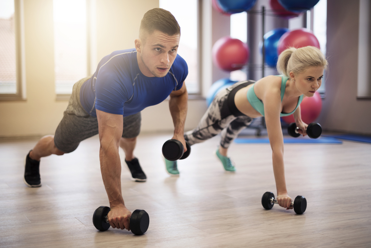 Couple making push ups with weights
