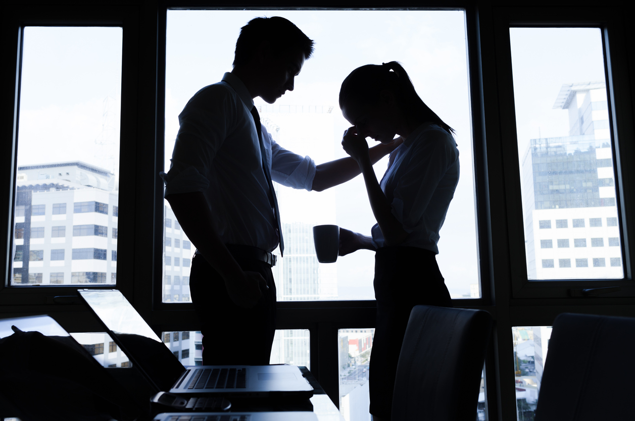 Businessman trying to calm down his colleague woman in the office. Business, teamwork, crisis concept
