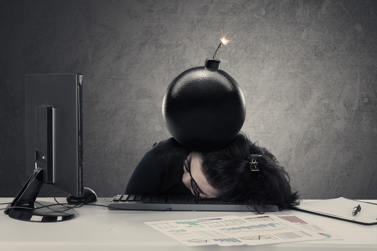 Frustrated entrepreneur sleeping on the desk with bomb over her head, concept of financial bankrupt